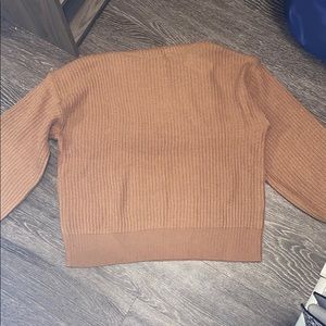 A tan turtle neck sweater.